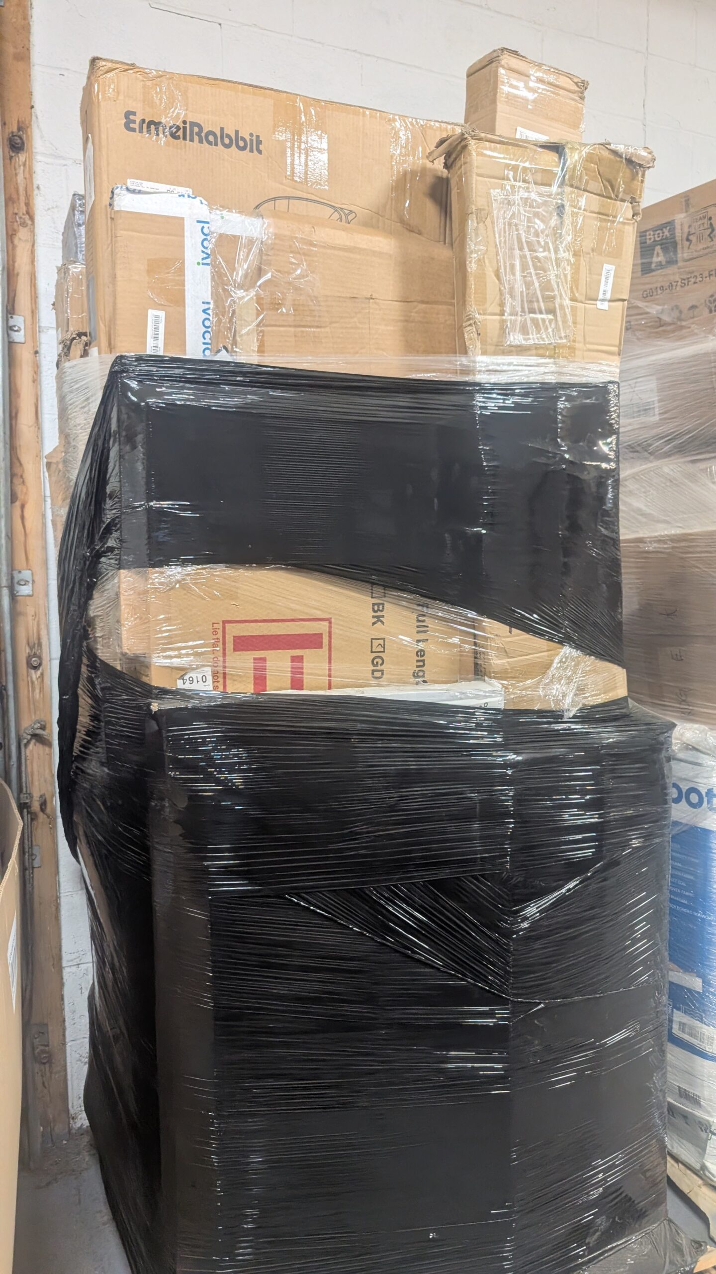 Mail Stack Mail stacked pallet of undelivered parcels and mixed returns wrapped for shipping from Save More Liquidations