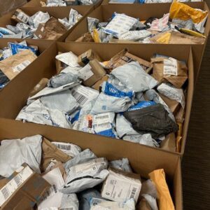 Unclaimed mail packages pallet — 20 boxes of US carrier-recovered unclaimed parcels from USPS, UPS, FedEx, and Amazon shipping flows for mystery-package resellers