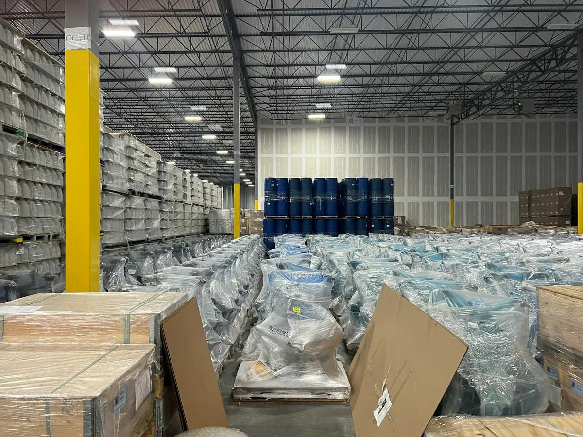 Shrink-wrapped liquidation pallets stacked in SaveMore warehouse